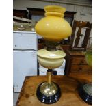 A Brass Column Oil Lamp With Yellow Tinted Reservoir & Shade