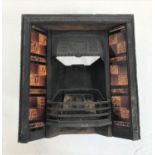 EDWARDIAN CAST IRON FIREPLACE decorated with floral motifs to the hood and flanked by brown and