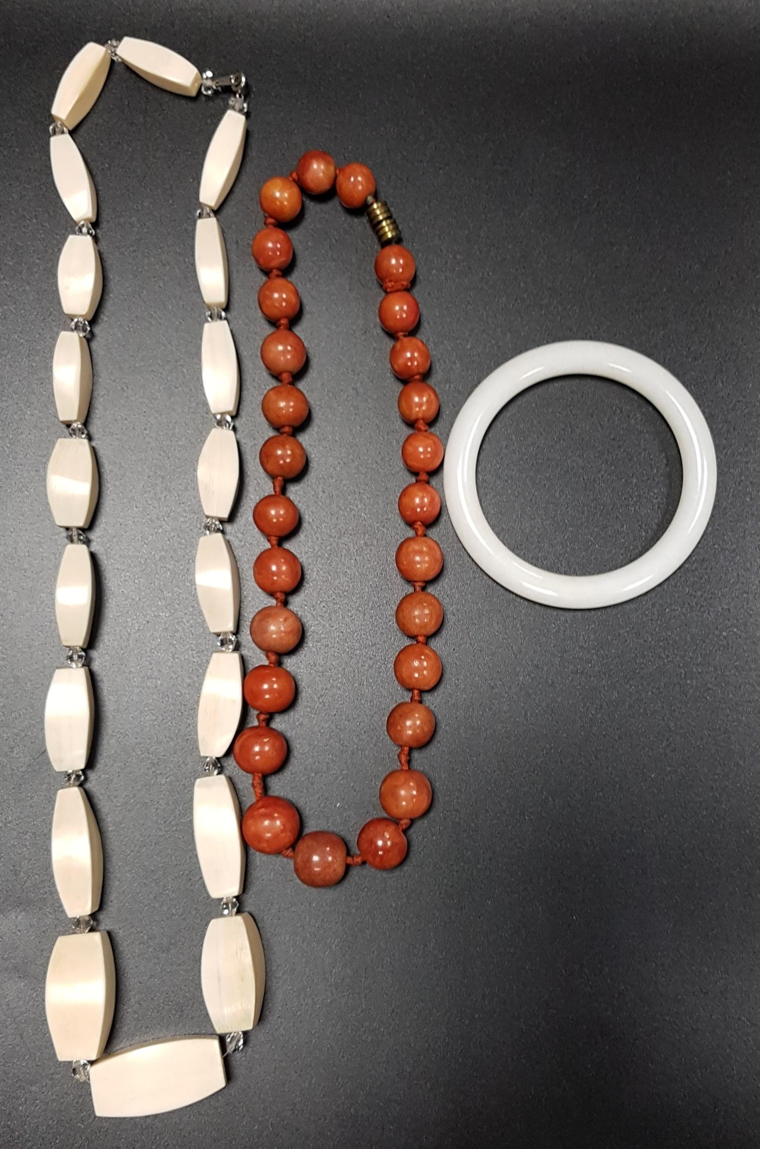 IVORY BEAD NECKLACE with graduated lozenge shaped beads, a white jadeite bangle and a graduated