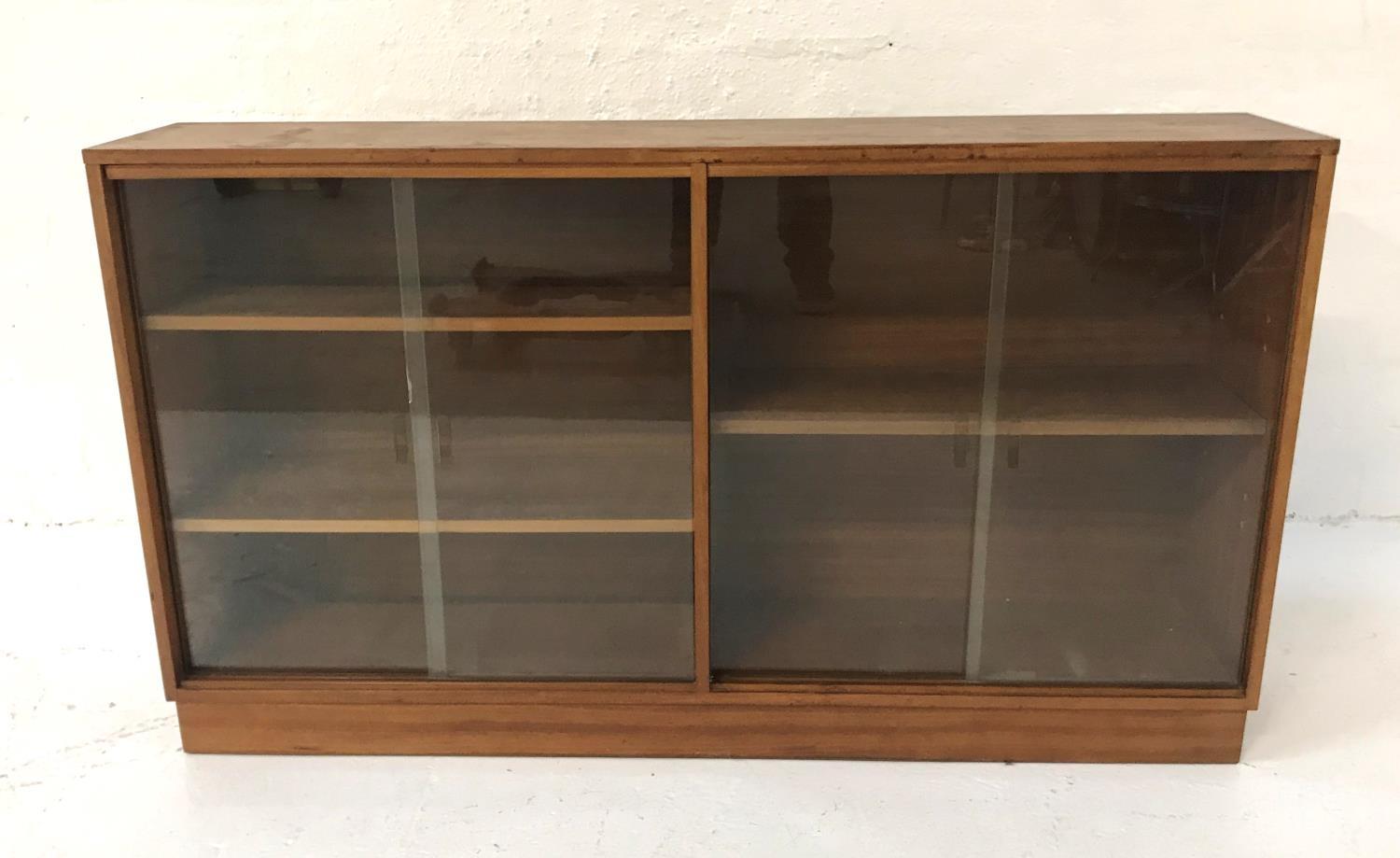TEAK CABINET with a rectangular top above two pairs of glass sliding doors with a shelved
