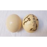 UNUSUAL OSTRICH EGG decorated with a female figure, drilled to both ends, together with a plain