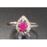 RUBY AND DIAMOND CLUSTER RING the central pear cut ruby in sixteen diamond surround, on nine carat