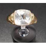 CLEAR GEM SET DRESS RING the central faceted top cushion cut gemstone flanked by further small