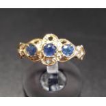 SAPPHIRE THREE STINE RING the three round cut sapphires in pierced and scroll setting, on nine carat