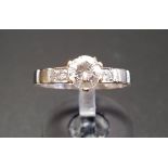 CZ SOLITAIRE RING on Egyptian eighteen carat white gold shank with further small CZ stones to the