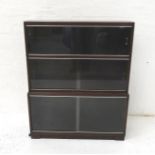 MINTY MAHOGANY SIDE CABINET with three pairs of glass sliding doors, standing on a plinth base,