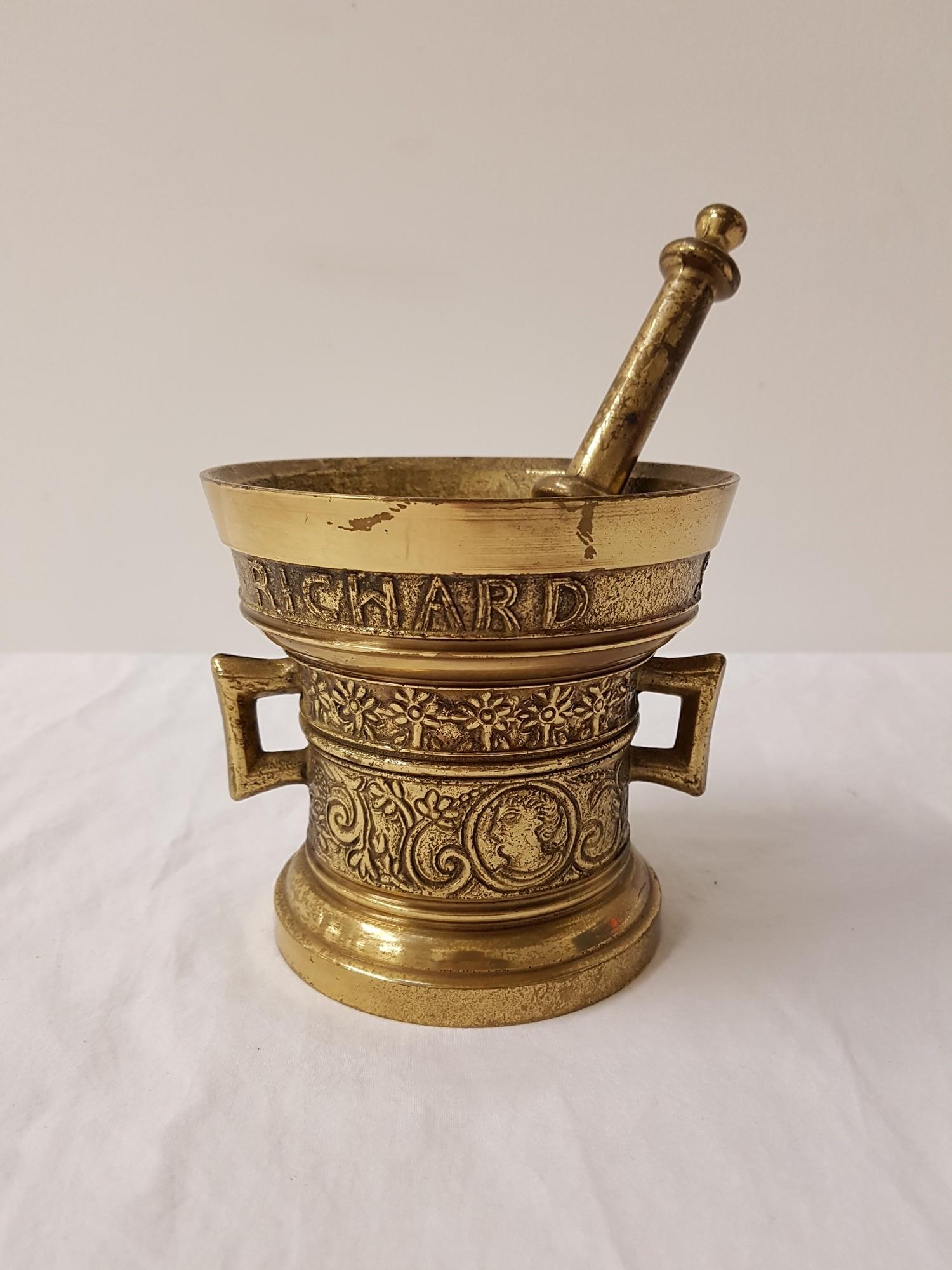 BRASS MORTAR AND PESTLE of tapering form with embossed decoration