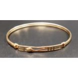 NINE CARAT GOLD MACKINTOSH STYLE BANGLE with pierced tendril and motif decoration, approximately 5.5