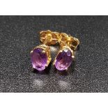 AMETHYST STUD EARRINGS the oval cut amethysts in unmarked gold and with fourteen carat gold