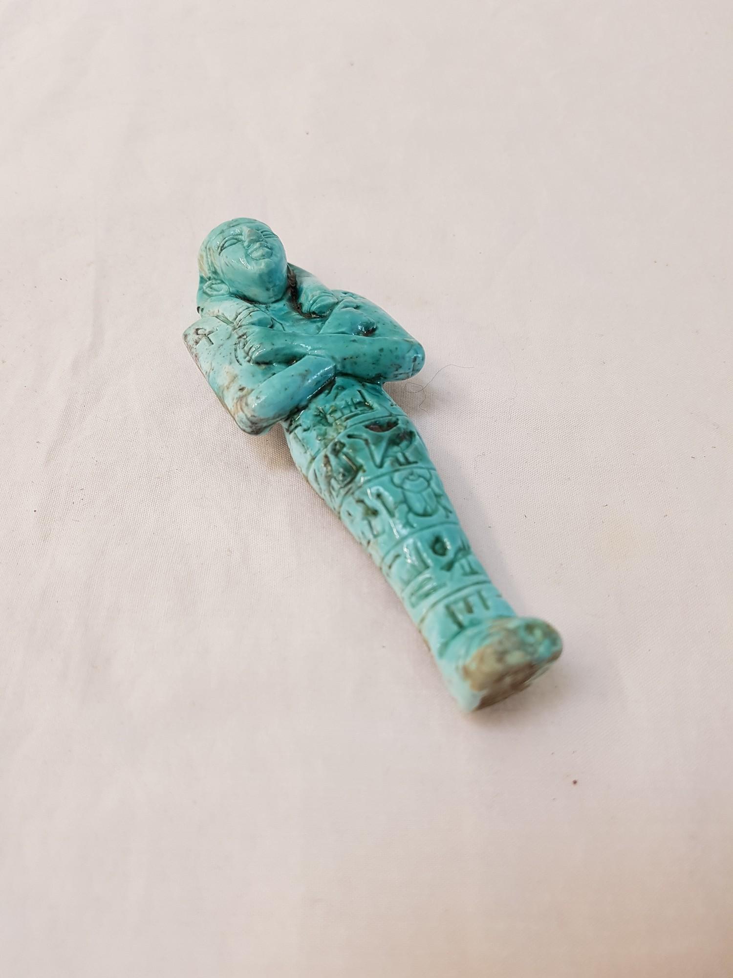 EGYPTIAN PORCELAIN FIGURE of a pharaoh with his arms crossed over his chest, in a turquoise glaze,