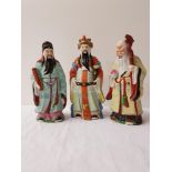THREE CHINESE PORCELAIN FIGURINES depicting scholars in colourfull robes, 28cm, 26cm and 25cm