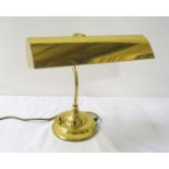 BRASS DESK LAMP raised on a circular base with a shaped column and adjustable lamp hood