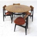 G PLAN TEAK DINING TABLE with a circular top standing on shaped ebonised supports, 121cm diameter,