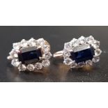 PAIR OF DARK BLUE AND WHITE SAPPHIRE CLUSTER EARRINGS the central emerald cut blue sapphires on each