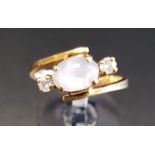MOONSTONE AND DIAMOND CROSSOVER DRESS RING the central oval cabochon moonstone flanked by round