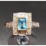 BLUE TOPAZ AND DIAMOND CLUSTER RING the central emerald cut blue topaz in illusion diamond set