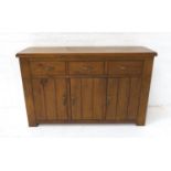 STAINED PINE SIDE CABINET with a plank top above three frieze drawers with three panelled cupboard