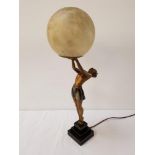 ART DECO SPELTER TABLE LAMP depicting a woman upright holding a globe aloft, raised on a square