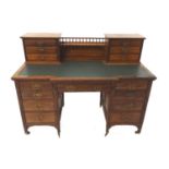 EDWARDIAN MAHOGANY BREAKFRONT KNEE HOLE DESK with a central gallery and shelf flanked by two
