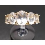 GRADUATED CLEAR GEM FIVE STONE RING on ten carat gold shank, ring size P