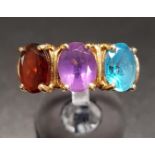 BLUE TOPAZ, AMETHYST AND GARNET THREE STONE RING the three oval cut gemstones on ten carat gold