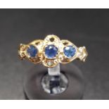 SAPPHIRE THREE STONE RING the three round cut sapphires in pierced and scroll setting, on nine carat