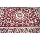 LARGE RED GROUND RUG with a central circular medallion surrounded by floral swags, encased by a