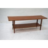 TEAK OCCASIONAL TABLE with a rectangular top standing on tapering supports united by an undertier,