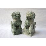 PAIR OF CHINESE DOGS OF FO each sat on a raised plinth with one paw raised and resting on a ball, in