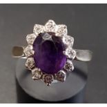 AMETHYST AND DIAMOND CLUSTER RING the central oval cut amethyst in surround of twelve illusion set