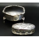 EDWARDIAN CIRCULAR SILVER TRINKET BOX the hinged cover with floral and scroll rim, raised on three