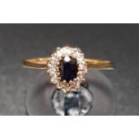 SAPPHIRE AND CLEAR GEM SET CLUSTER RING on nine carat gold shank, ring size M