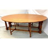 20TH CENTURY CLOVER OAK WAKE TABLE with shaped drop flaps supported by double gatelegs to each side,