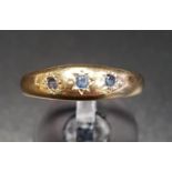 SAPPHIRE THREE STONE GYPSY STYLE RING in nine carat gold, ring size P, approximately 2.6 grams