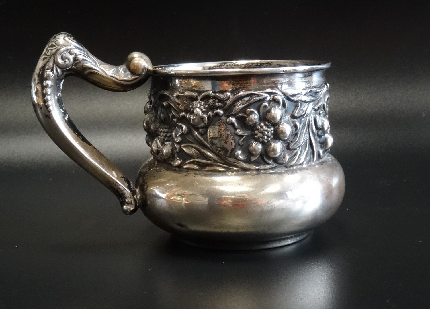 EARLY 20th CENTURY AMERICAN EMBOSSED SILVER MUG with a band of floral and scroll decoration and