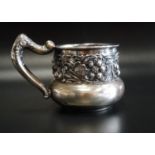 EARLY 20th CENTURY AMERICAN EMBOSSED SILVER MUG with a band of floral and scroll decoration and