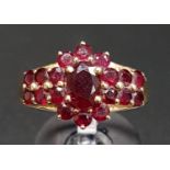 GARNET CLUSTER DRESS RING the central oval cut garnet in surround of round cut garnets and with