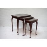 NEST OF MAHOGANY TABLES each with an inset glass top, standing on cabriole supports