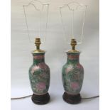 PAIR OF CHINESE STYLE POTTERY TABLE LAMPS of shaped form decorated with flowers and raised on