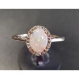 OPAL AND DIAMOND CLUSTER RING the central oval opal in diamond surround, on nine carat gold shank,
