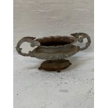 CAST IRON GARDEN URN of oval form with a scalloped rim above a body with floral decoration and