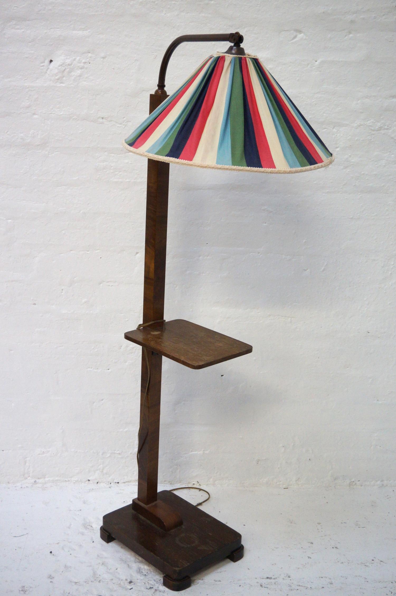 1930'S WALNUT STANDARD LAMP raised on an oblong base with a square column with a shelf, rising to