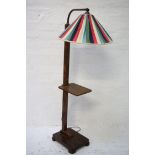 1930'S WALNUT STANDARD LAMP raised on an oblong base with a square column with a shelf, rising to