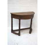 OAK DEMI LUNE SIDE TABLE the moulded top above a carved frieze with a central drawer, standing on