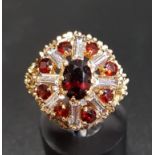 GARNET AND CZ CLUSTER COCKTAIL RING in shaped setting and on nine carat gold shank, ring size L