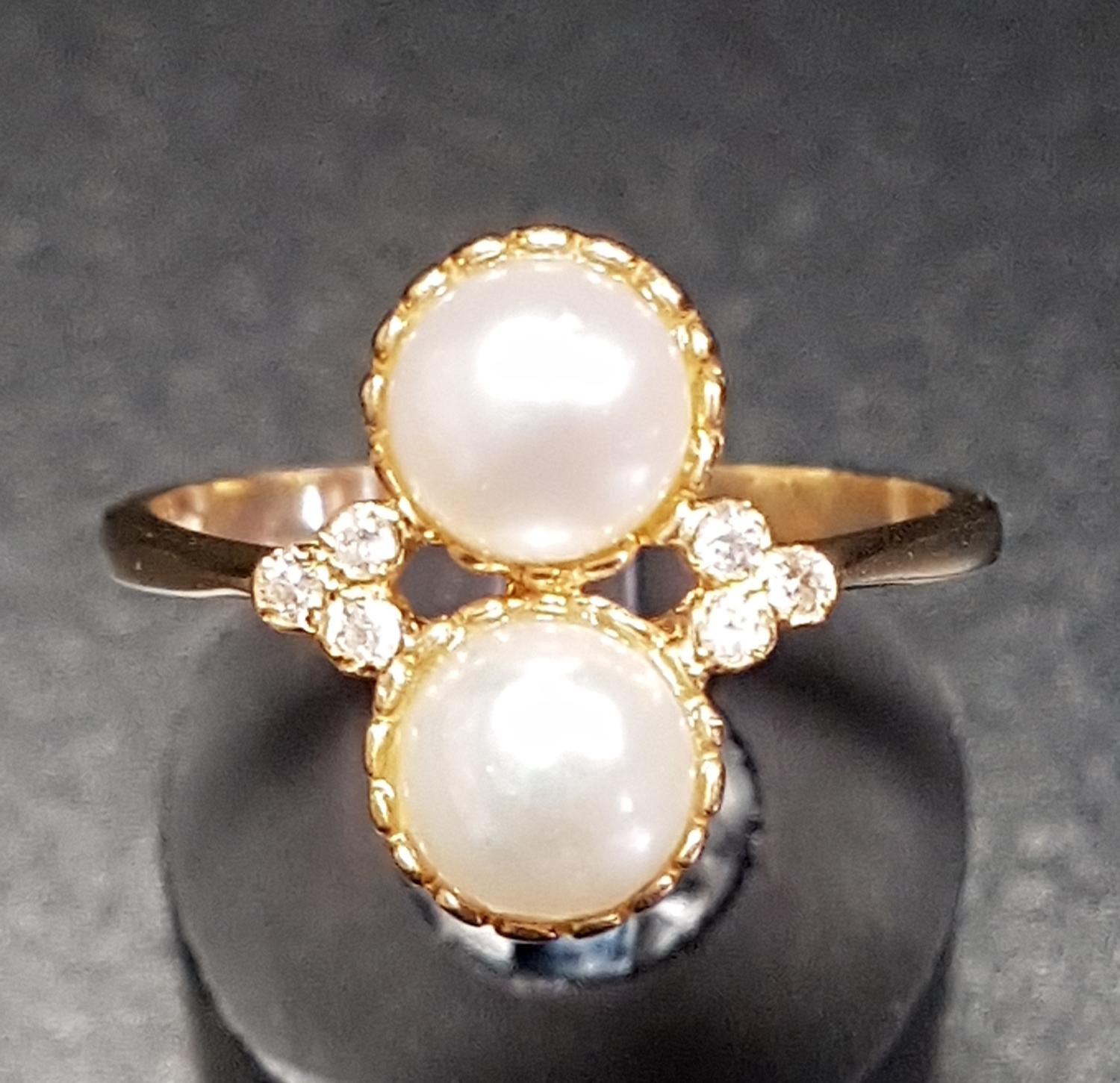 UNUSUAL PEARL AND DIAMOND RING the two vertically set pearls flanked by three small diamonds to each