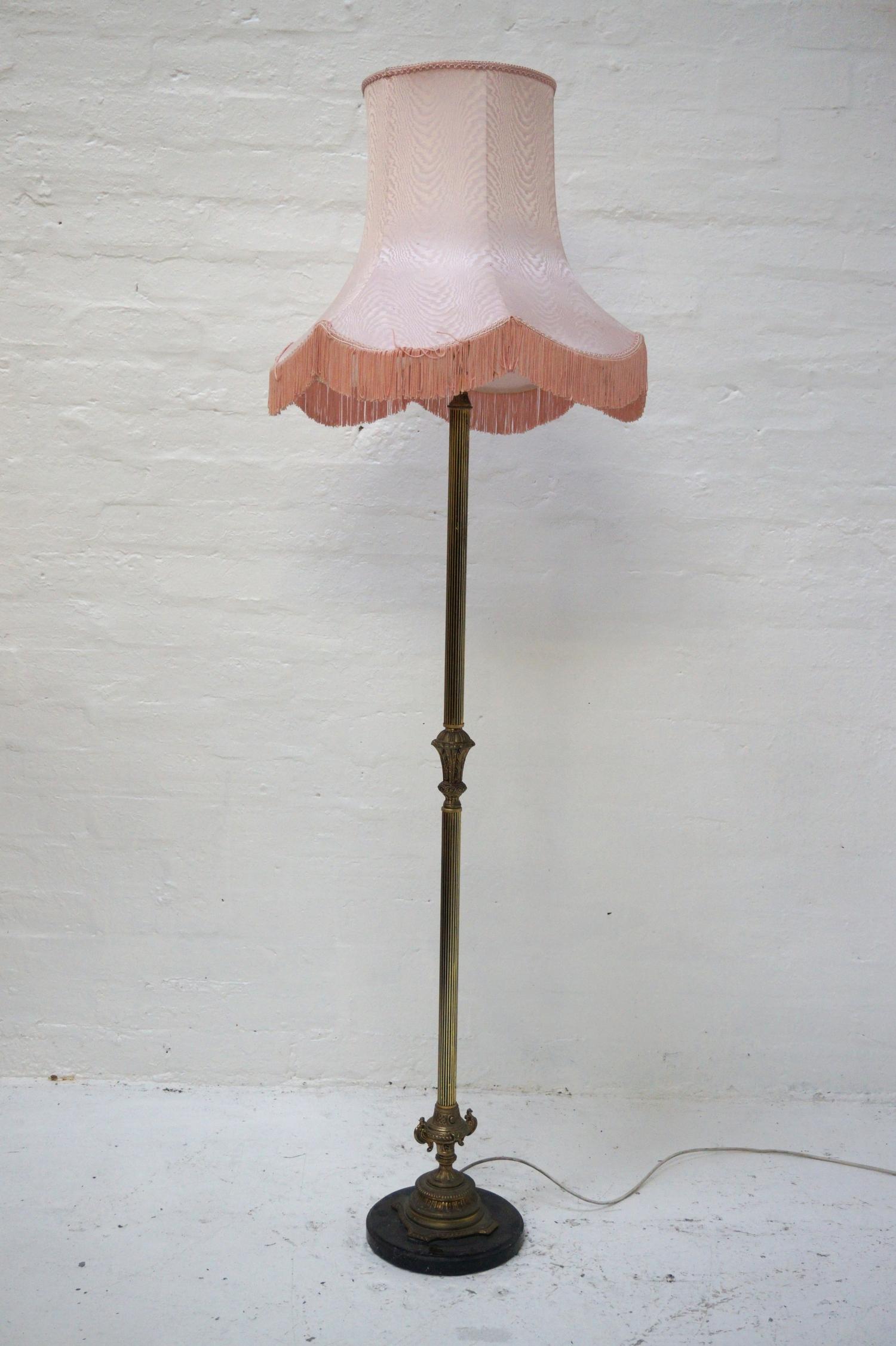 GILT METAL STANDARD LAMP raised on a circular slate base with a Corinthian style column and a shaped