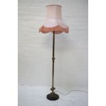 GILT METAL STANDARD LAMP raised on a circular slate base with a Corinthian style column and a shaped