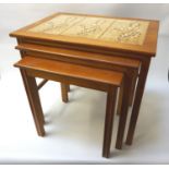 1970'S NEST OF TEAK TABLES with the largest having three inset oak leaf decorated tiles, standing on