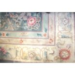LARGE CHINESE WASH RUG with a pale green ground and floral motifs encased by a cream and pink